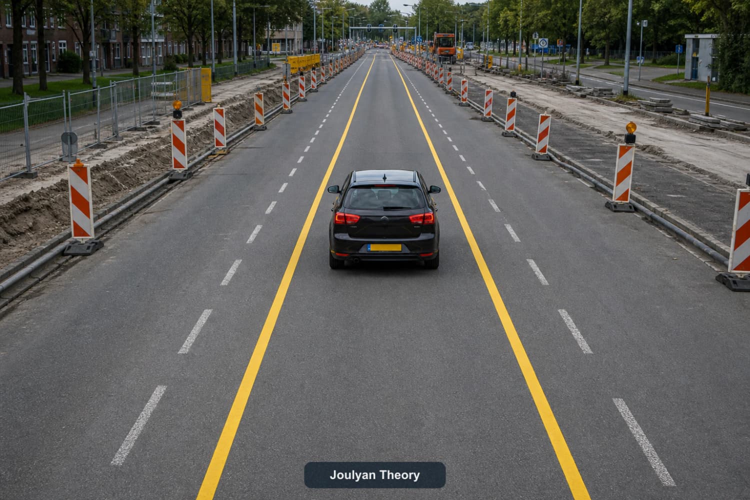 Car travels between two continuous temporary yellow guide lines while old white markings remain visible