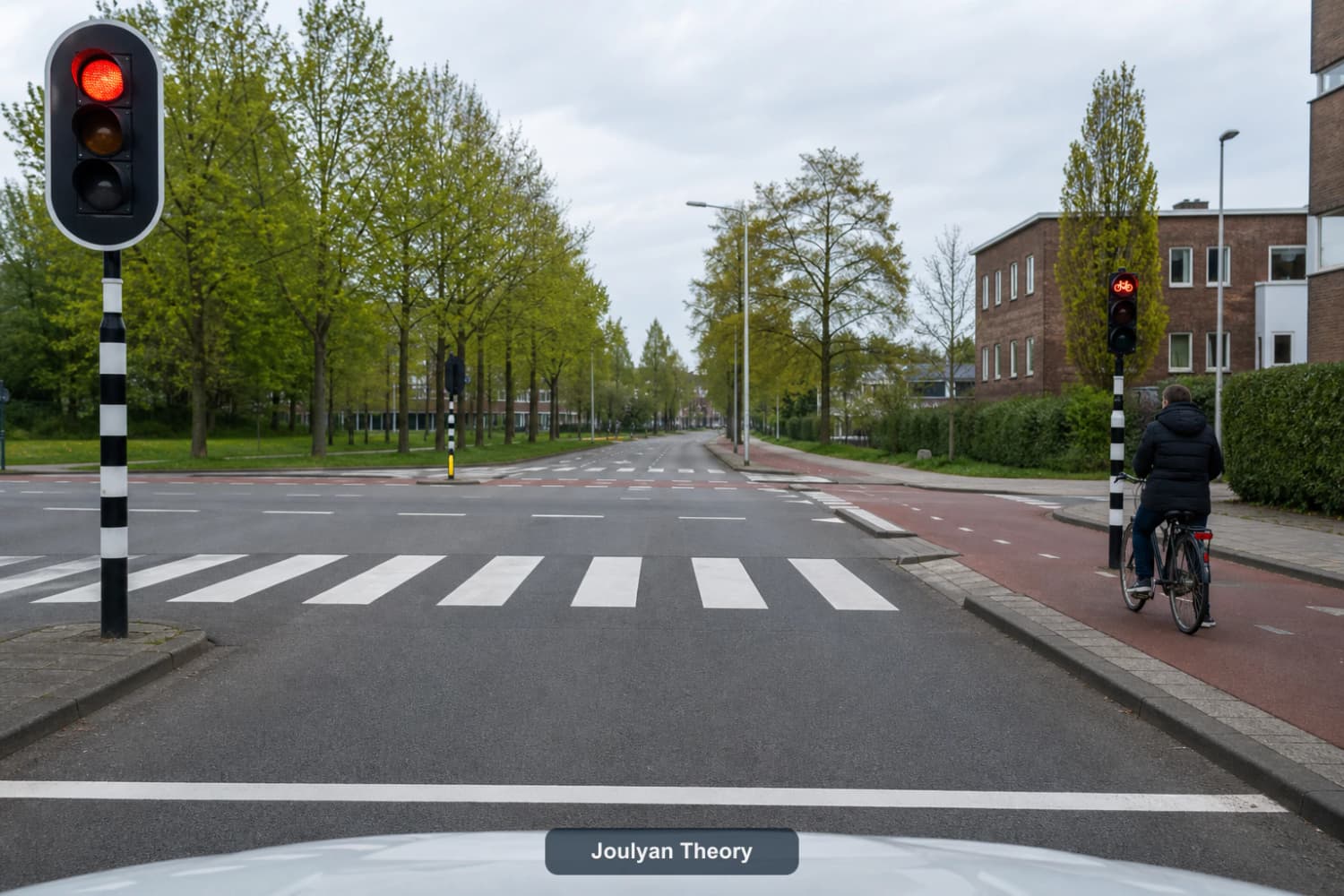 Driver view of a Dutch junction with a stop line, zebra crossing, red vehicle signal and separate bicycle signal
